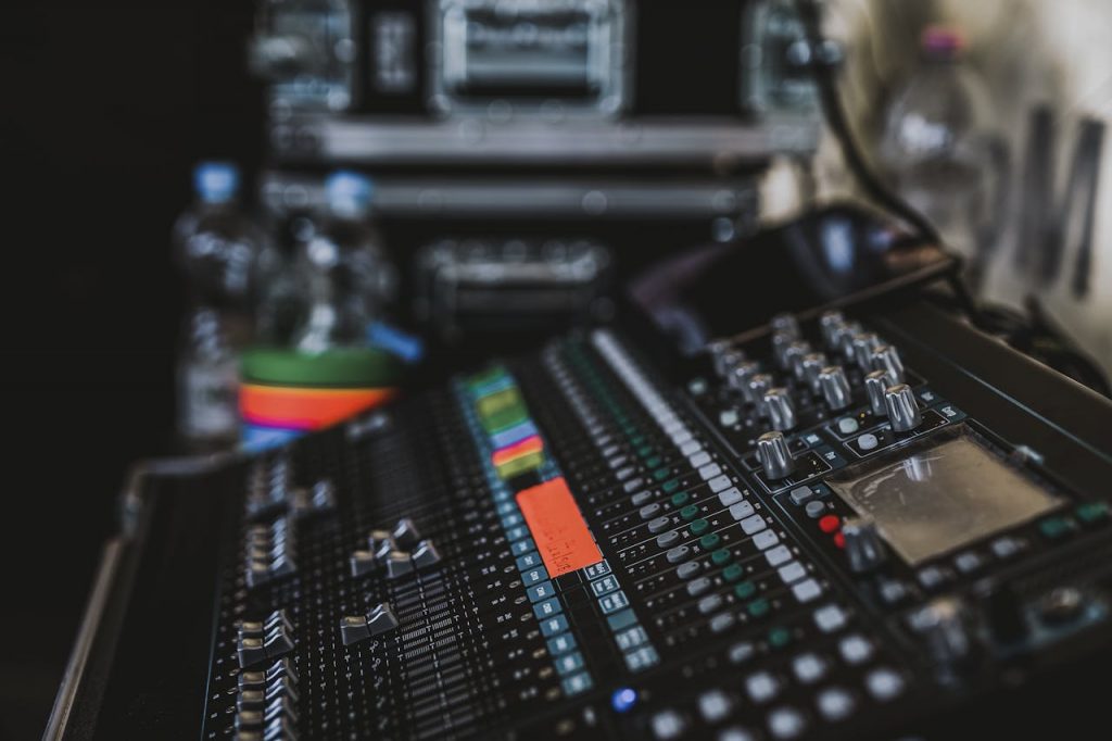 pexels-photo-690779 Close-up of a professional audio mixer with various knobs and sliders in a music studio setting.